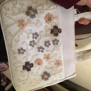 White purse embroidered with beaded flowers